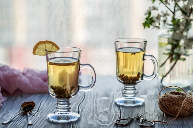 Té verde fresco. Taza de té con hojas de té verde en la mesa de madera. Té con limón