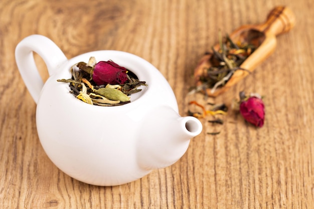 Té verde con frutas especias pétalos de rosa en una tetera