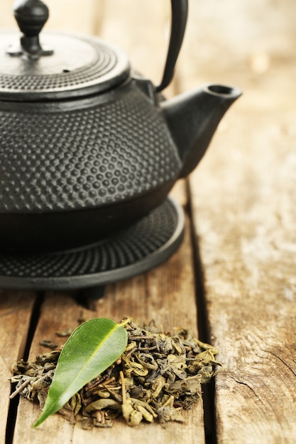 Té verde con hojas sobre la mesa de madera antigua