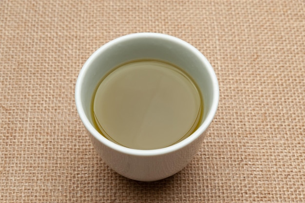 Té verde japonés tradicional aislado sobre fondo de yute. De cerca. Vista superior.