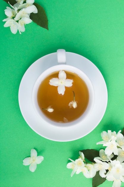 Té verde jazmín en taza con flores