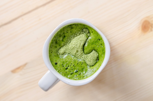 Té verde con leche en mesa de madera