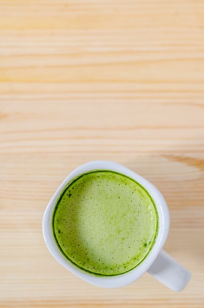 Té verde con leche en mesa de madera