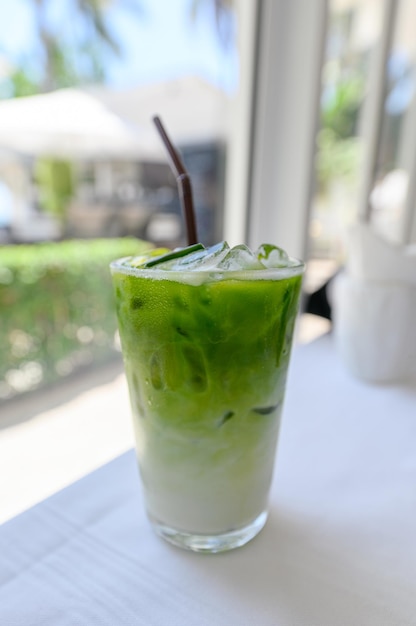 Té verde matcha helado con leche con paja en vaso