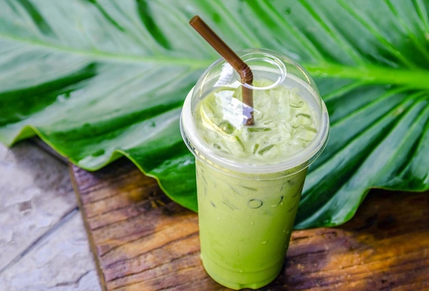 Té verde matcha latte helado con leche en un vaso de plástico con hielo