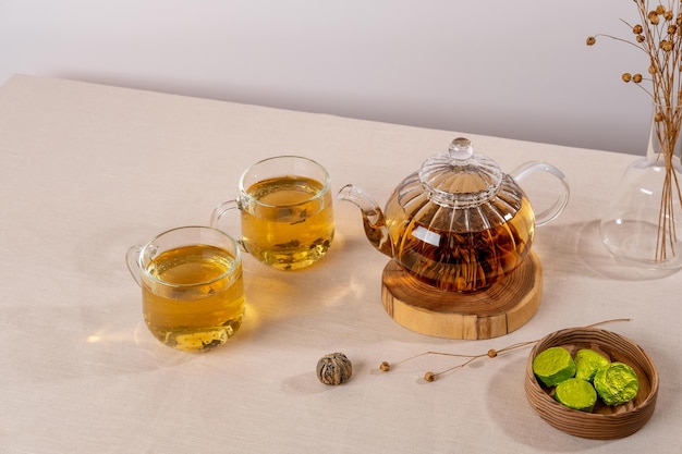 Té verde oolong en una tetera de vidrio sobre la mesa El té caliente está en las tazas de vidrio