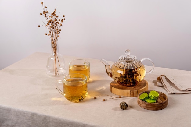 Té verde oolong en una tetera de vidrio sobre la mesa El té caliente está en las tazas de vidrio