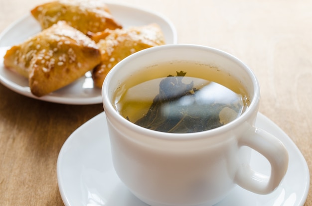 Té verde y pasteles en mesa de madera rústica