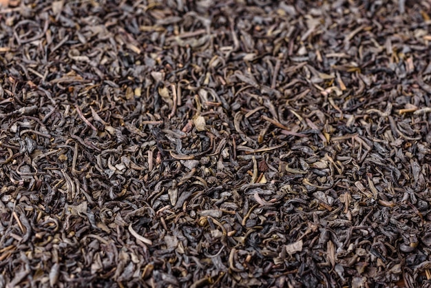 Té verde seco en platillo blanco sobre un fondo de hormigón oscuro