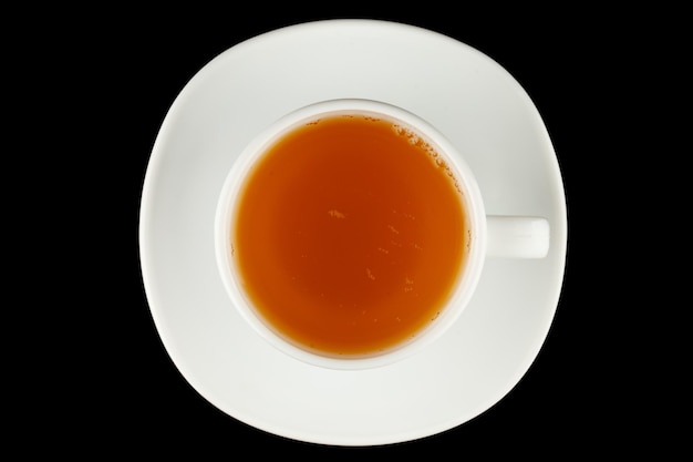 Té verde en una taza sobre un fondo negro