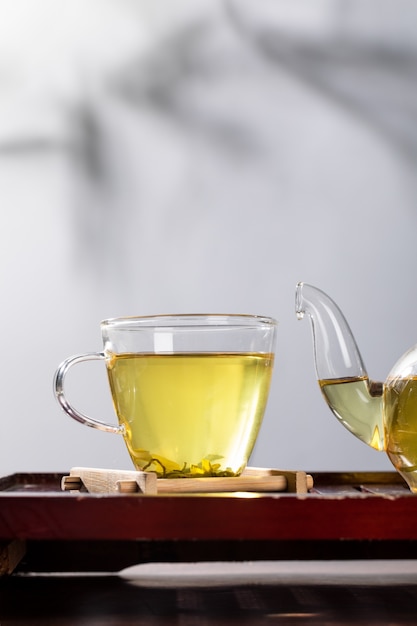 Té verde en taza y tetera de vidrio