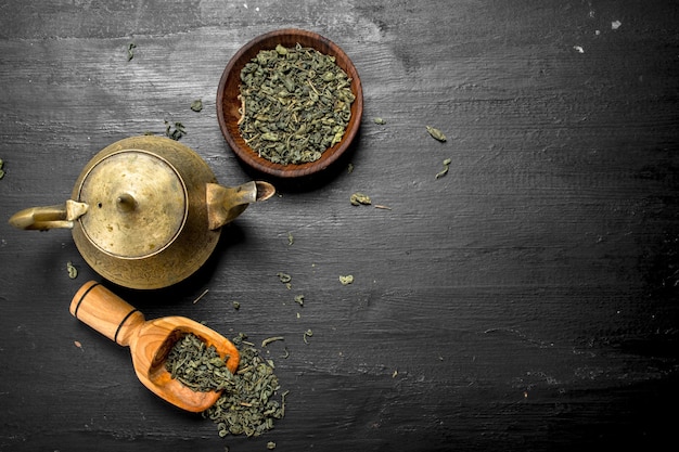 Té verde con una tetera en pizarra negra