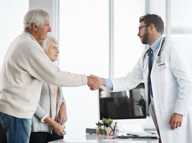 Te veré de nuevo la próxima semana Captura recortada de un joven médico seguro de sí mismo estrechando la mano de un paciente mayor después de una consulta