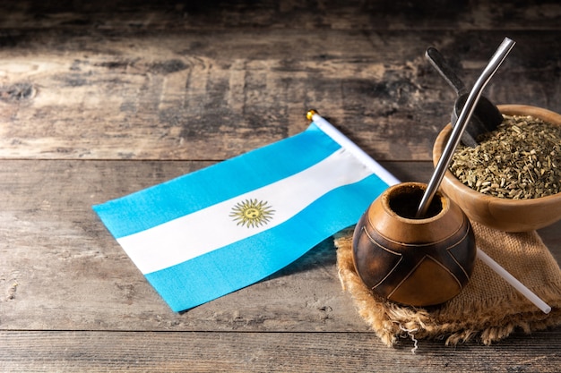Té de yerba mate y bandera Argentina en mesa de madera. Bebida tradicional argentina