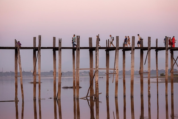 Teakholzbrücke mit Menschen, die den Fluss Irrawaddy überqueren, Mandalay, Myanmar