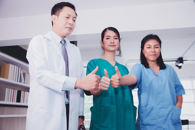 Team asiatischer Arzt und Krankenschwester Stehender zuversichtlicher Krankenhaushintergrund