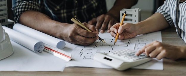 Foto team construction engineers working at construction site with blueprint on table