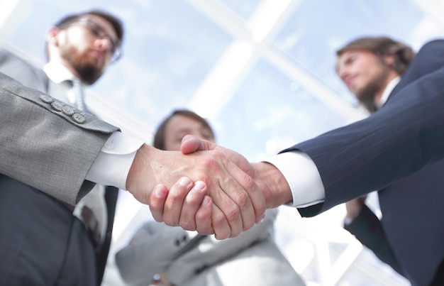 Team, das einen Business-Handshake-Partner betrachtet