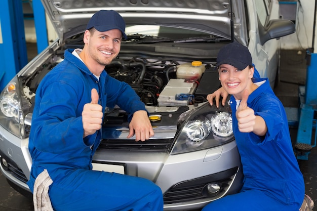 Team der Mechaniker, die an der Kamera lächeln