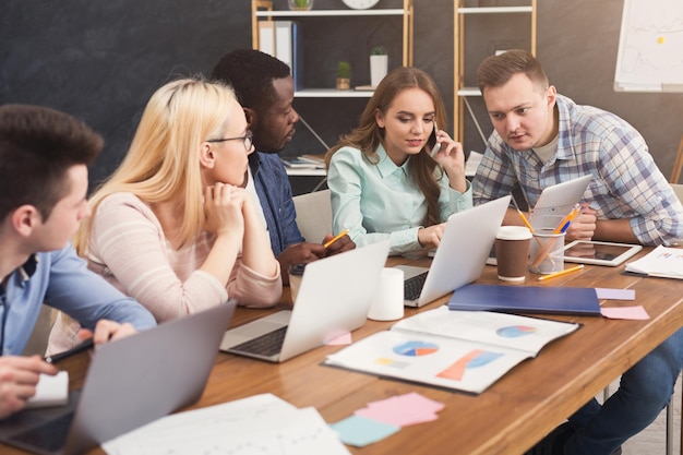 Foto team junger programmierer, die in einem softwareentwicklungsunternehmen arbeiten, auf laptops tippen, neue spiele oder apps testen, speicherplatz kopieren