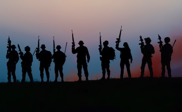 Team Spezialeinheiten. Soldat Sturmgewehr mit Schalldämpfer. Silhouette Action Soldaten halten Waffen. Militär- und Gefahrenkonzept.