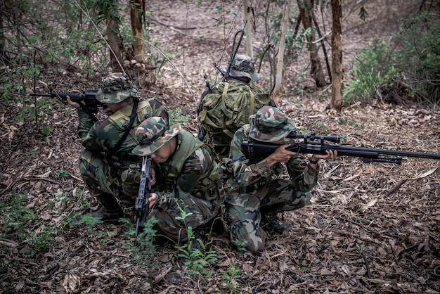 Team von Armeesoldaten mit Maschinengewehr, die sich im Wald bewegen. Thailändischer Milizsoldat in Kampfuniformen im Wald