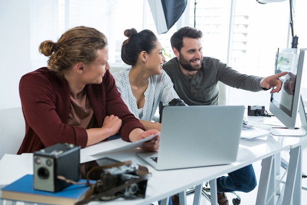 Team von Fotografen, die über Computer am Schreibtisch arbeiten