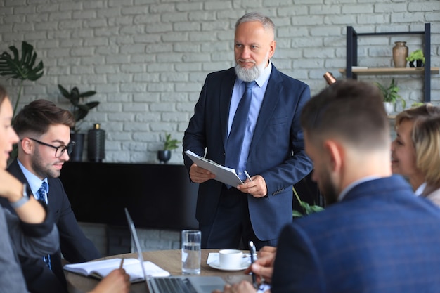 Team von Geschäftsleuten, die im Kreativbüro am Tisch diskutieren.