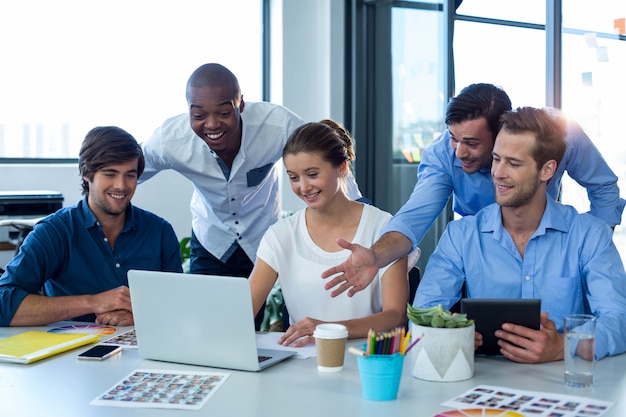 Team von Grafikdesignern diskutiert über Laptop