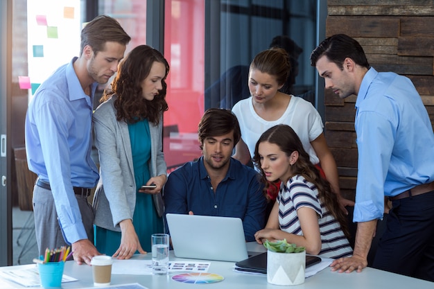 Team von Grafikdesignern diskutiert über Laptop