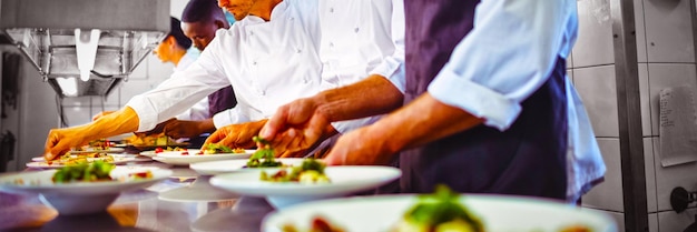 Team von Köchen, die das Essen auf der Theke garnieren