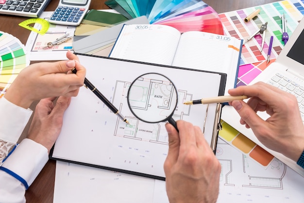 Team von kreativen Designern, die Hausplan im Büro diskutieren