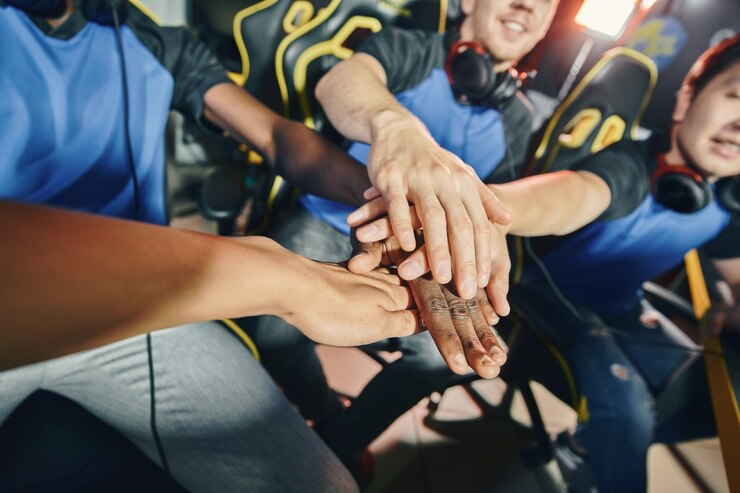 Foto team von professionellen cyber-sport-spielern, die hände zusammenlegen, bevor sie mit dem esport-turnier beginnen