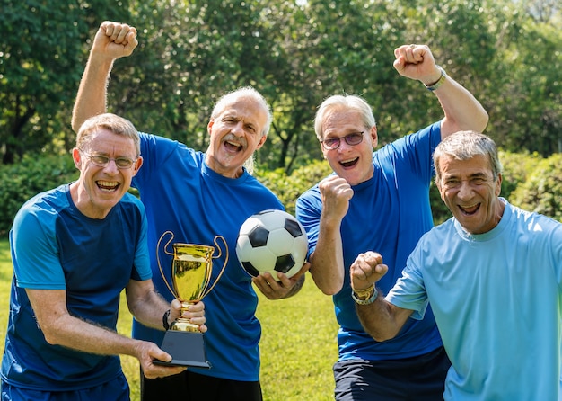 Team von reifen Fußballspielern, die den Pokal gewinnen