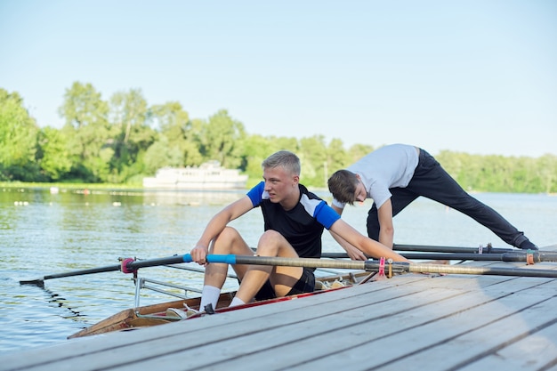 Team von zwei Jungs im Teenageralter Kajakfahren auf dem Fluss. Aktiver Jugend-Lifestyle, Wassersport, Kajak, Kanu