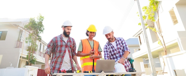 Team Working Laptop Professionelles Maschinenbauingenieur-Team mit Schutzhelm, das in der Fertigungsfabrik auf der Baustelle arbeitet