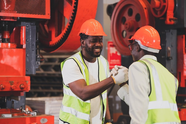 Teamarbeit afroamerikanischer Arbeiter in der FabrikSchwarzer Mann afro arbeitet schwerindustriell