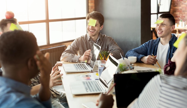 Foto teambildung. glückliche kollegen, die spielen, wer ich bin, gemeinsam großartigen zeitvertreib haben, platz kopieren