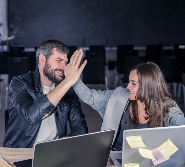 Teamwork-Erfolg Fröhlicher Mann und Frau geben High Five im Büro oder Hörsaal