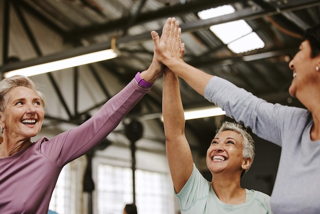 Foto teamwork fitness und high five von seniorinnen im fitnessstudio, die trainingsziele feiern sportziele feiern und eine gruppe von freunden mit händen zusammen für erfolgsmotivation und trainingserfolge