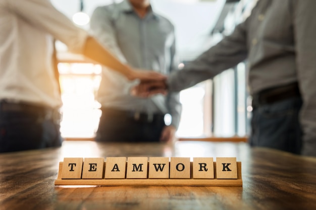 Teamwork Wort auf Holz Tisch mit Business-Teamwork verbinden Hände zusammen Konzept im Hintergrund.
