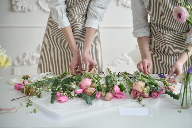 Teamwork Zwei junge, schöne Floristen kreieren einen Blumenstrauß