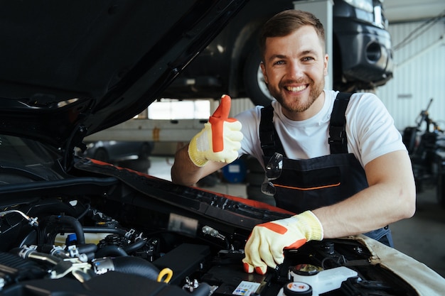 Techniker, der an der Überprüfung und Wartung des Autos in der Werkstatt arbeitet