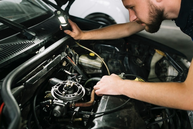 Foto techniker, der automotor überprüft