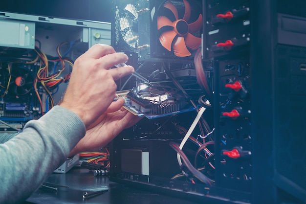 Foto techniker, der einen computer repariert, der prozess des ersetzens von komponenten auf dem motherboard.