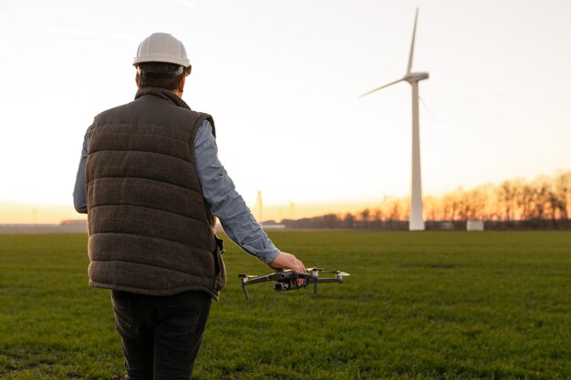 Foto techniker-ingenieur in einer windturbinen-kraftgenerator-station startet eine drohne zur visuellen steuerung von