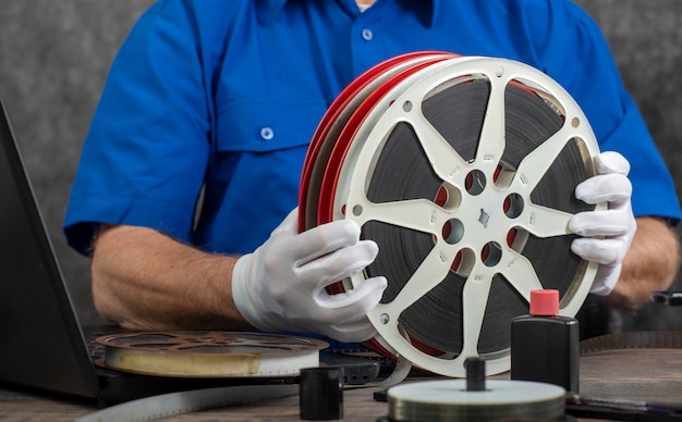 Techniker mit weißen Handschuhen, die alten Film 16mm digitalisieren