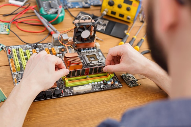 Techniker-Upgrade des Computers hautnah. Mikrochipkomponente für die Renovierung von oben im Motherboard. Wartungsunterstützung und Reparaturservicekonzept.