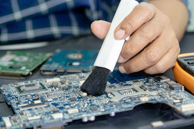 Techniker verwenden Bürste und Luftgebläsekugel, um Staub im Leiterplattencomputer zu entfernen. Reparatur-Upgrade- und Wartungstechnologie