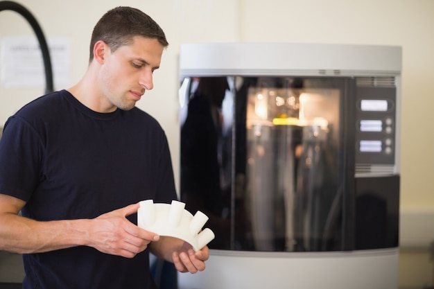 Technikstudent, der das Objekt gedruckt vom Drucker 3d hält